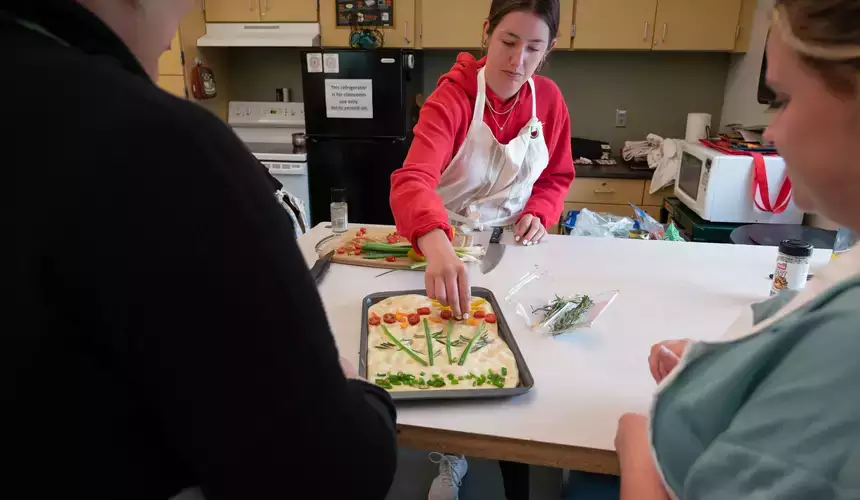 Students watch as a tray of focaccia is prepared. 