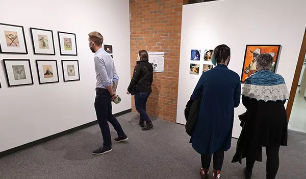 People admiring various pieces of art