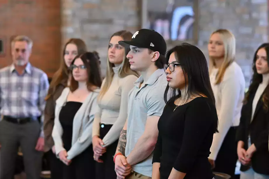Student inductees stand for the initiation pledge