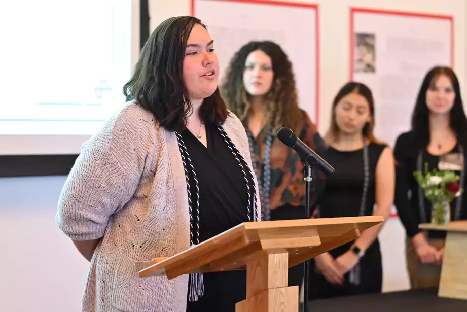 Tri-Alpha eboard Vice President Brianna Trent speaks to those being inducted