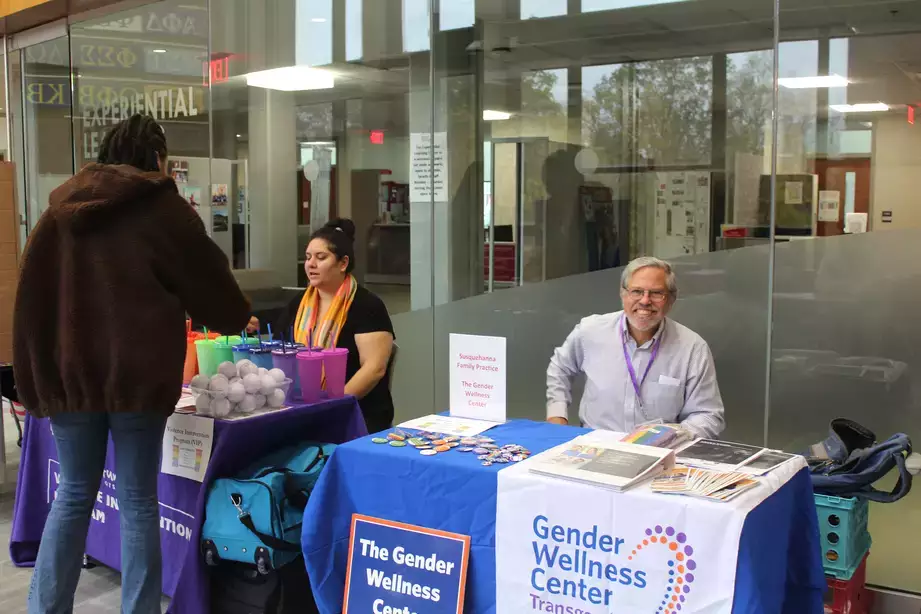 "Gender Wellness Center" table at a fair during a PRISM Conference
