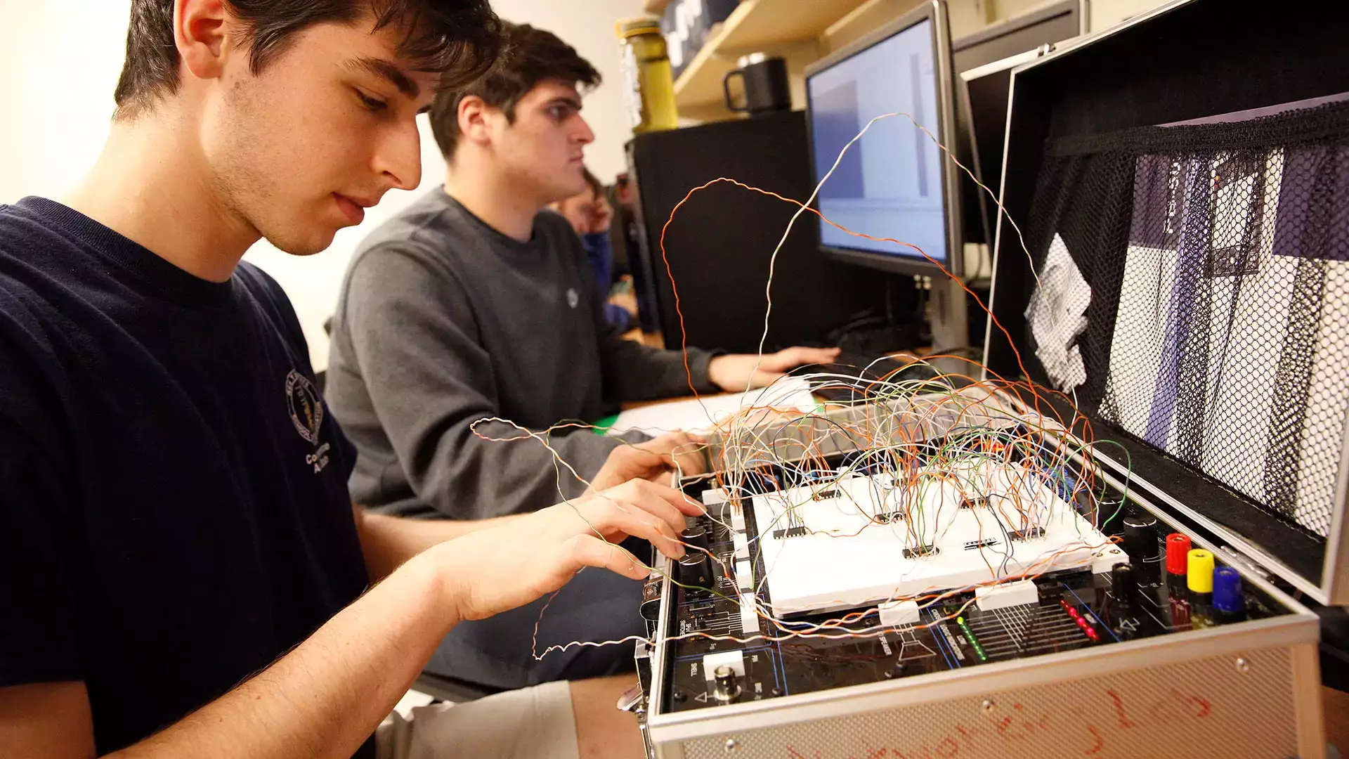 Students work on wiring CADET II trainer circuit boards to run simple programs