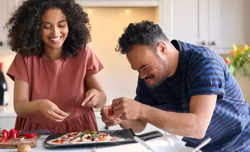Woman works with special needs individual in the kitchen